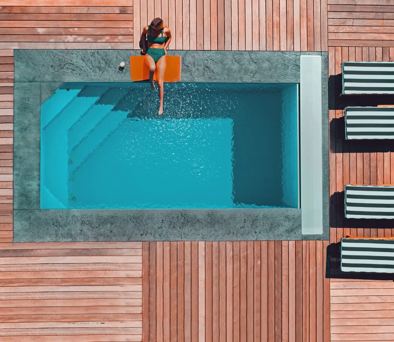 Installed VESSEL precast concrete pool with wood decking — aerial view